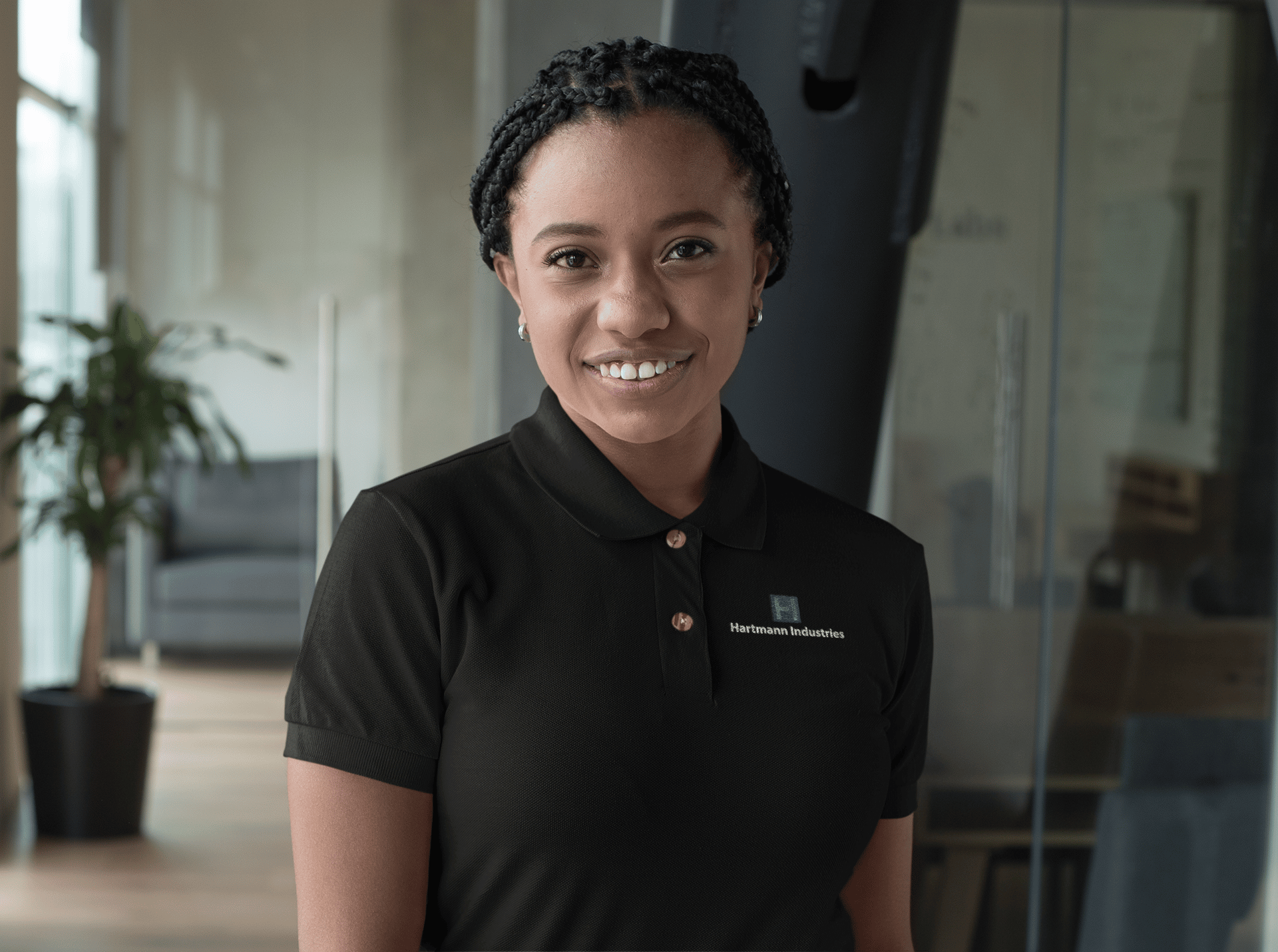 Smiling woman wearing a Hartmann Industries polo shirt in office